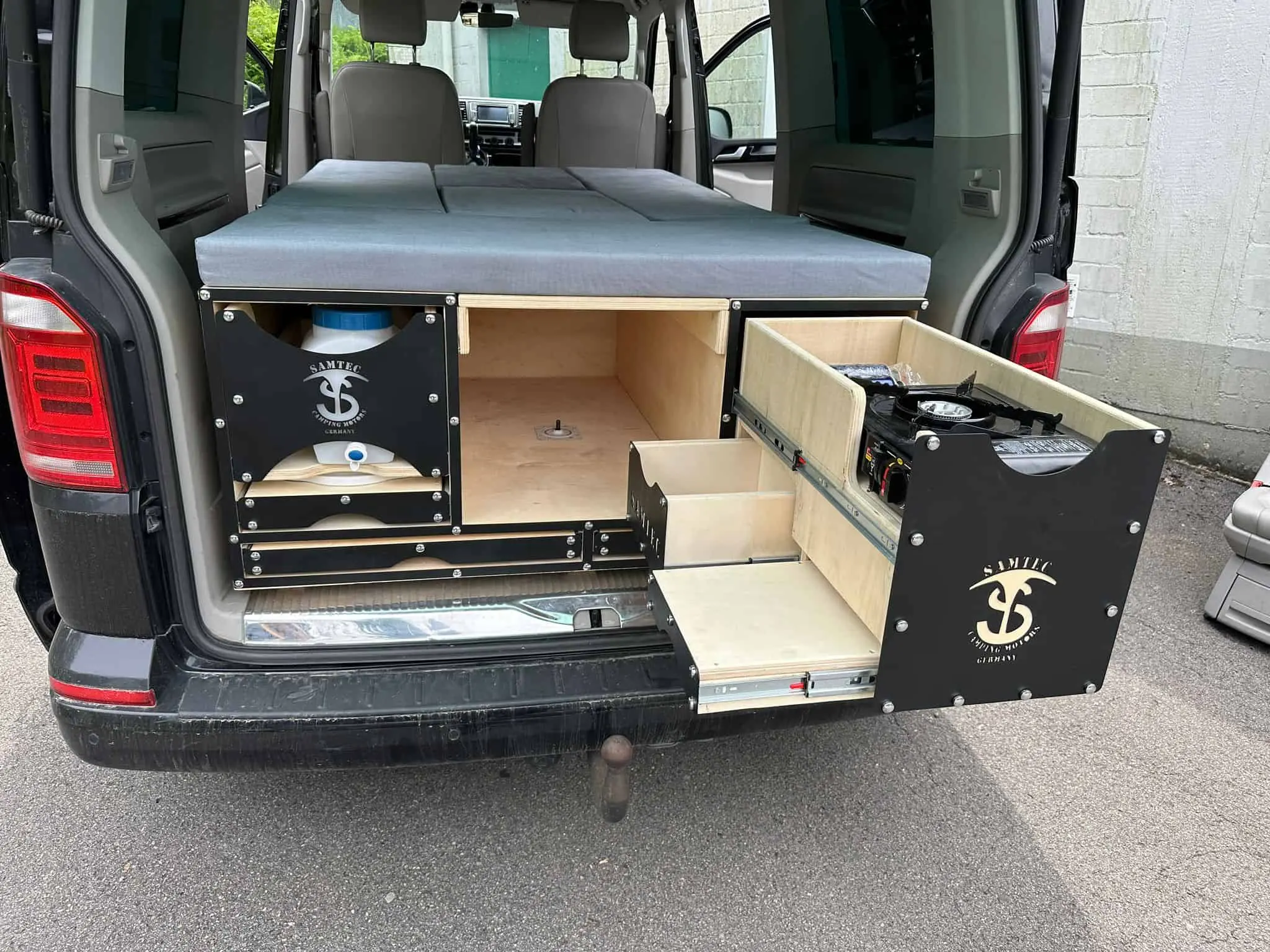 Campingbox mit ausgezogenem Küchen- und Stauraummodul in einem Van